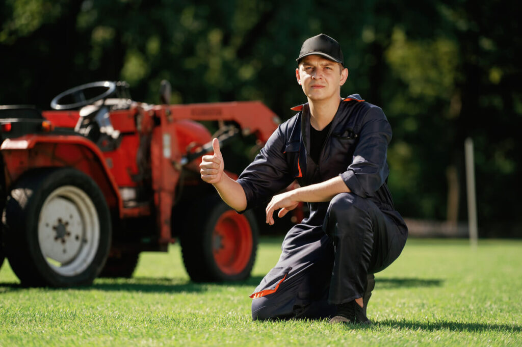with-thumb-up-man-is-with-utility-tractor-with-gr-69JPWER.jpg